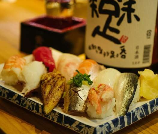 Bandeja de sushi y botella de sake en un restaurante japonés
